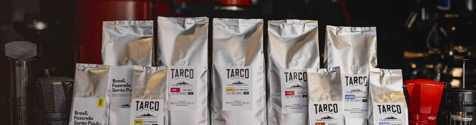 Bolsas de café Tarco y accesorios presentados en fila