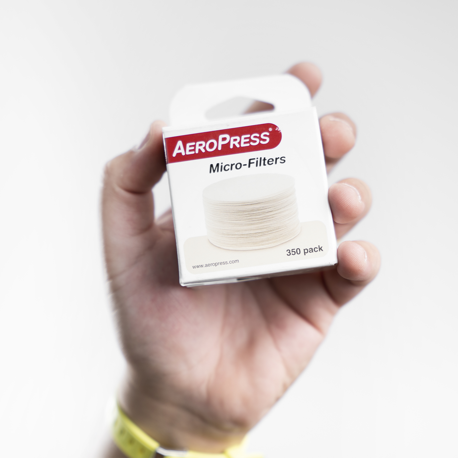 Paquete de 350 filtros de AeroPress sostenido por una mano